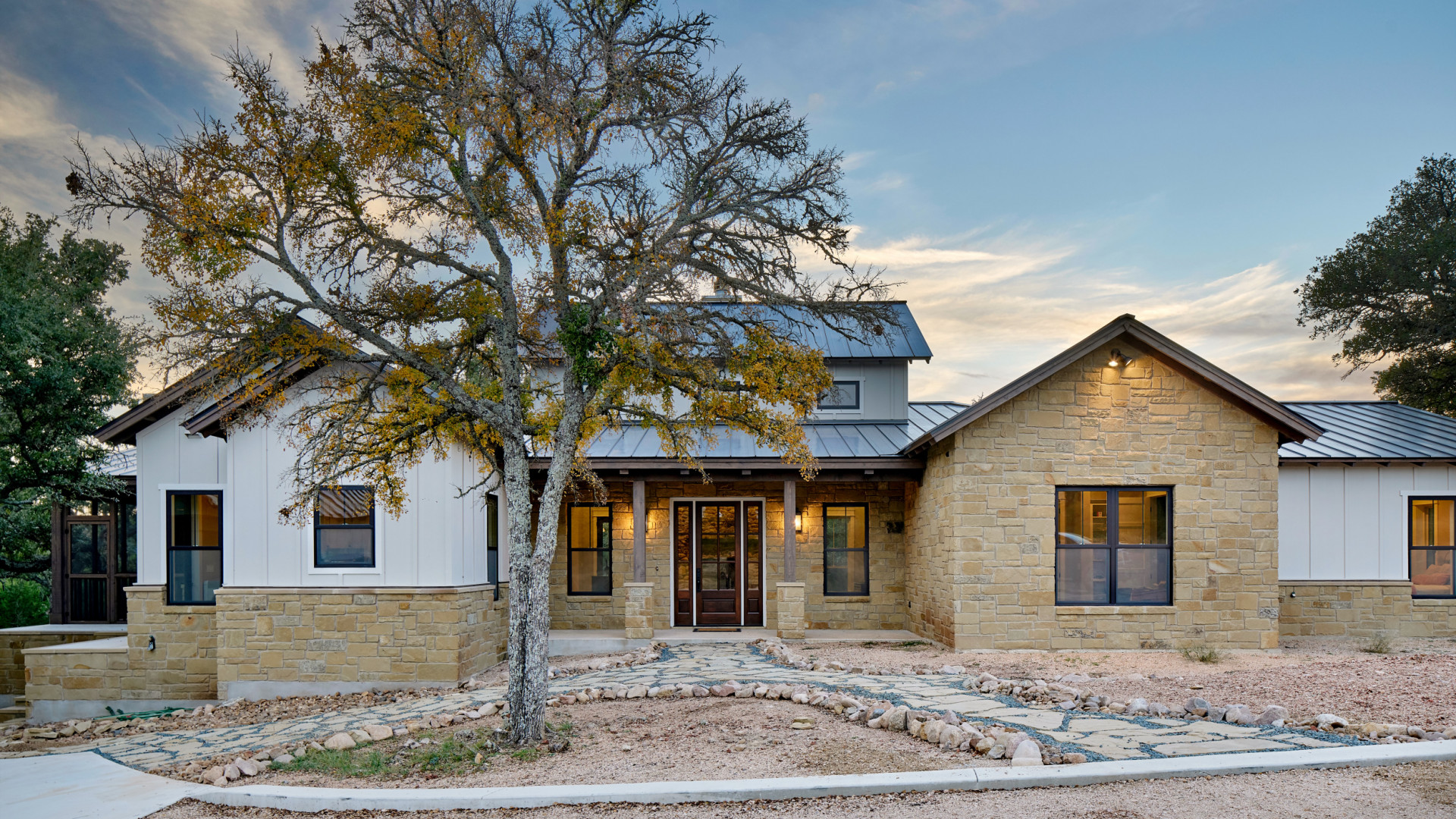 Front view of custom luxury home boasting a custom stone exterior, Lake LBJ TX